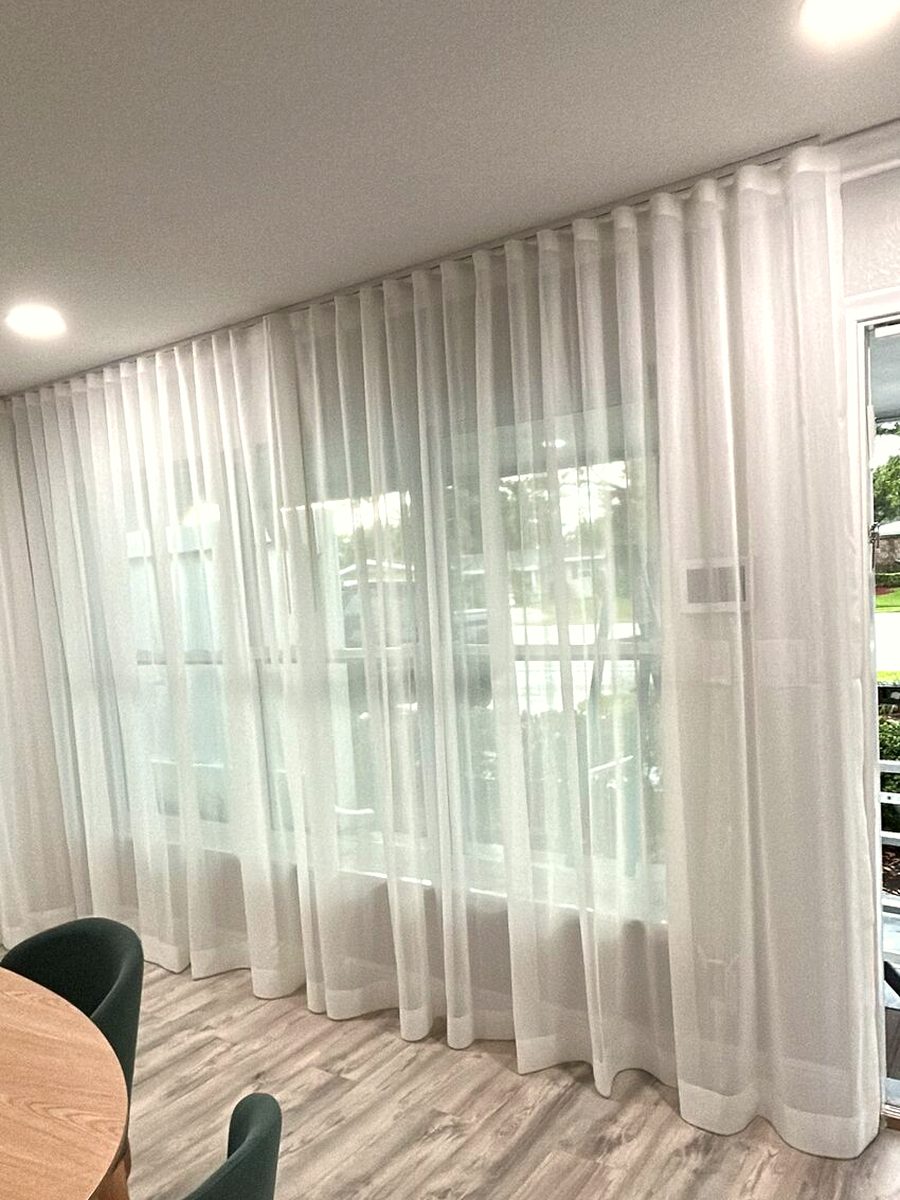 Ripple fold sheer, full sliding wall. The wave repeats the same width from the first carrier to the last, across a run with no break to hide a correction.